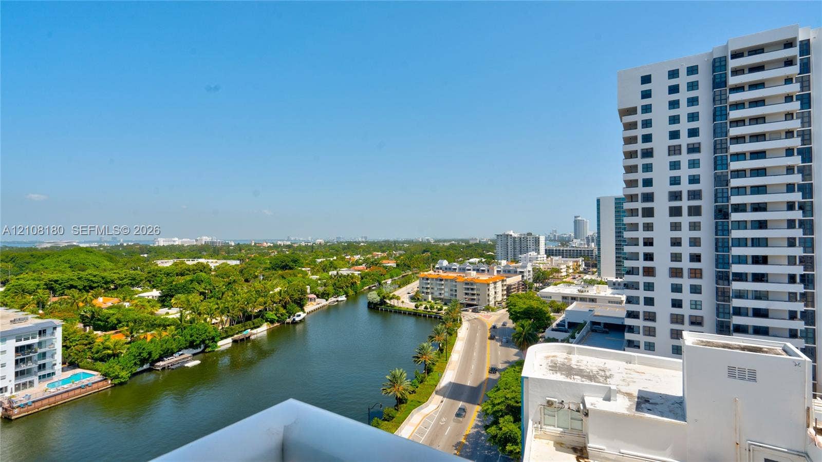 2457 Collins Avenue, #1501, Miami Beach, FL 33140 Elevated exterior vantage point featuring panoramic urban scenery, waterway, mature canopy trees, and high-rise architecture