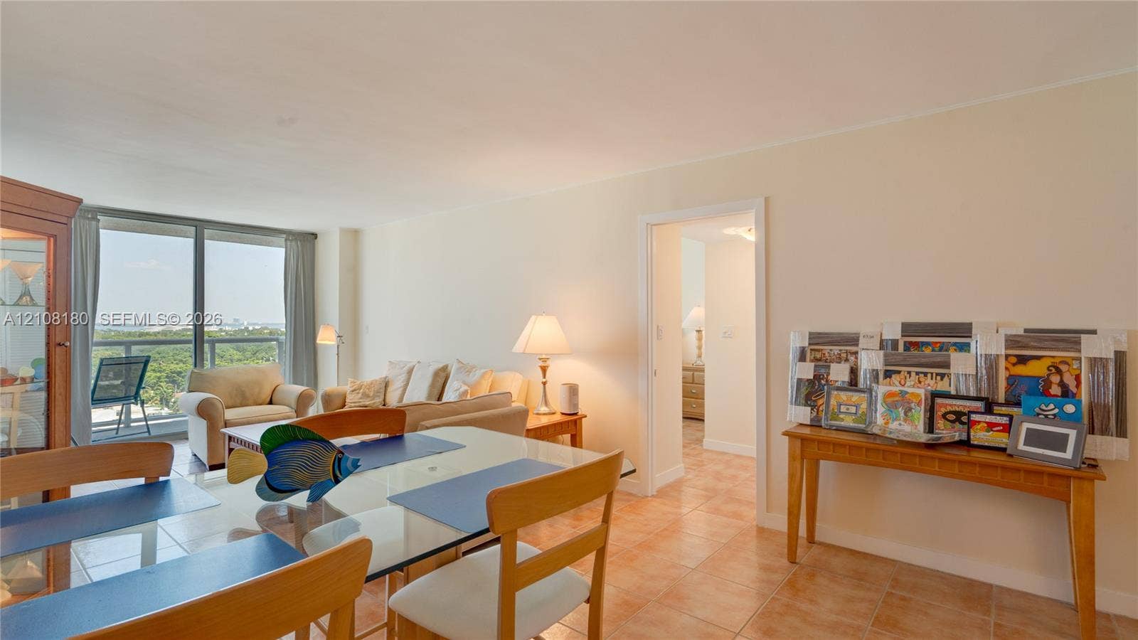 2457 Collins Avenue, #1501, Miami Beach, FL 33140 Open-concept interior featuring large-format tile flooring and floor-to-ceiling glass doors providing access to a private balcony