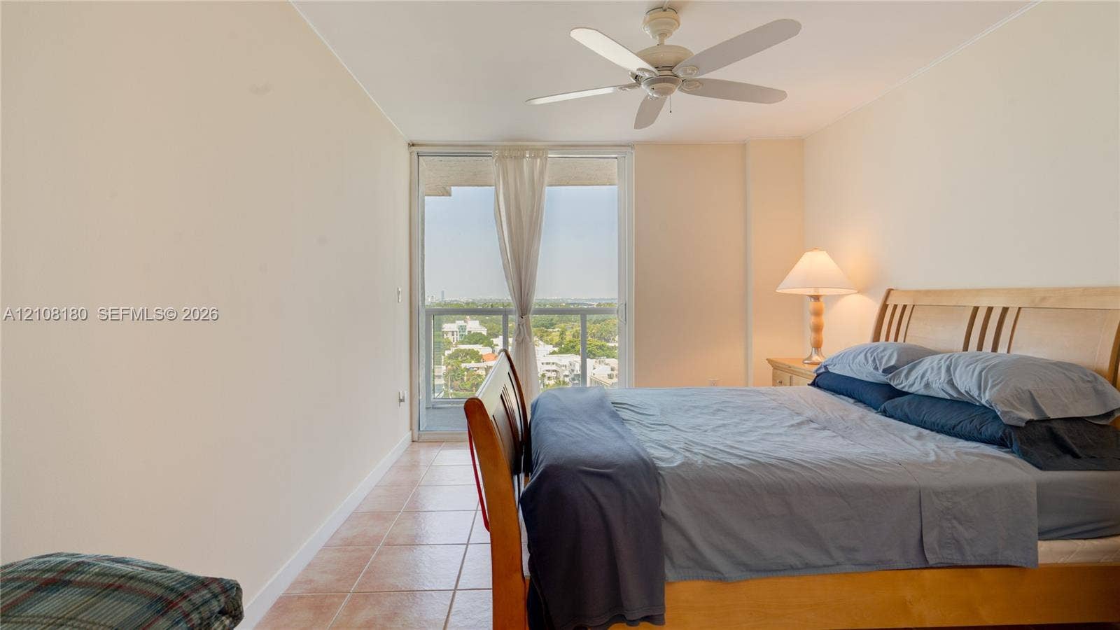 2457 Collins Avenue, #1501, Miami Beach, FL 33140 Tile flooring, ceiling fan, and large glass sliding doors leading to an exterior balcony