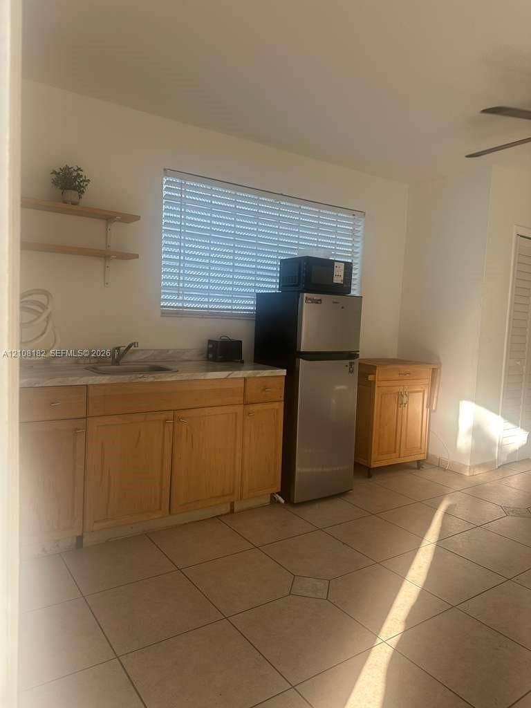 930 N 16th Avenue, #2, Hollywood, Hollywood, FL 33020 Kitchenette featuring wood cabinetry, stone-finish countertops, stainless steel sink with a metallic faucet, and ceramic tile flooring