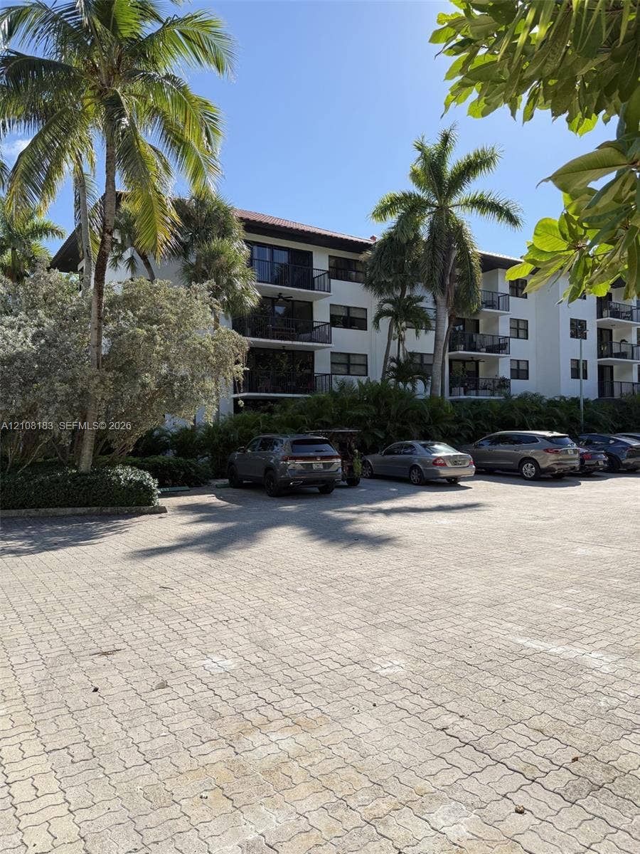 101 Ocean Lane Drive, #205, Key Biscayne, Key Biscayne, FL 33149 Multi-story residential building featuring private balconies, paver-stone parking area, and mature palm landscaping