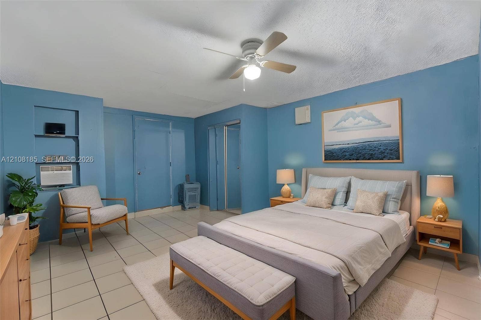 Ceramic tile flooring, built-in wall shelving, and a ceiling fan with integrated lighting