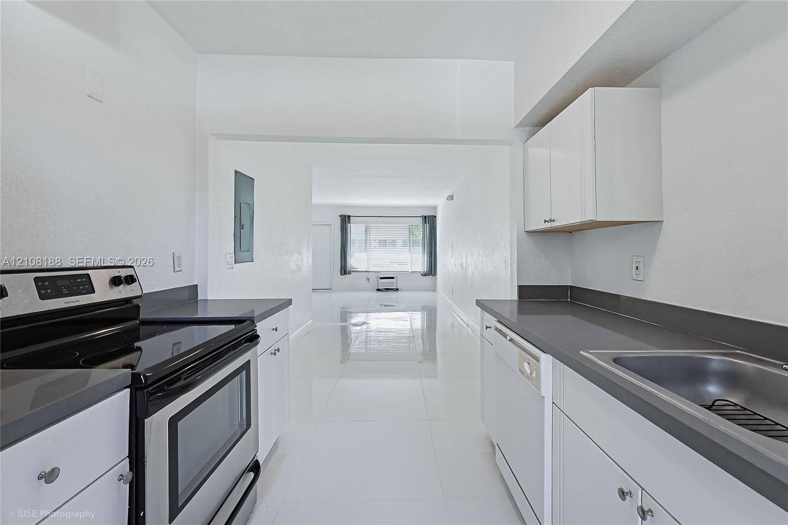 9790 E Bay Harbor Drive, #3N, Bay Harbor Islands, Bay Harbor Islands, FL 33154 Kitchen featuring white cabinetry, solid-surface countertops, stainless steel electric range, built-in dishwasher, and large-format tile flooring
