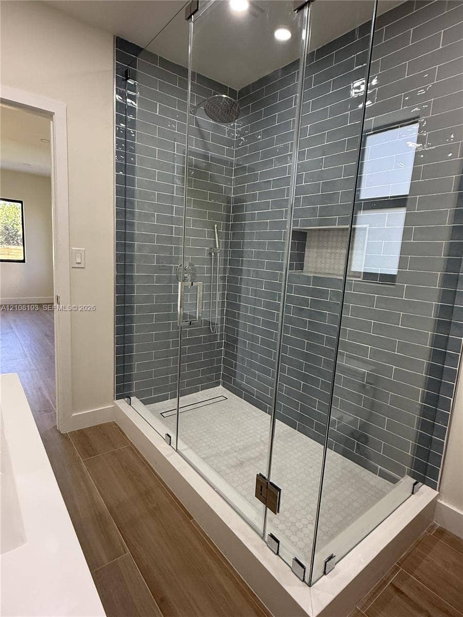 1929 SW 21st Street, #0, Miami, Miami, FL 33145 Walk-in shower featuring gray subway tile walls, a frameless glass enclosure, recessed wall niche, linear floor drain, and rainfall showerhead