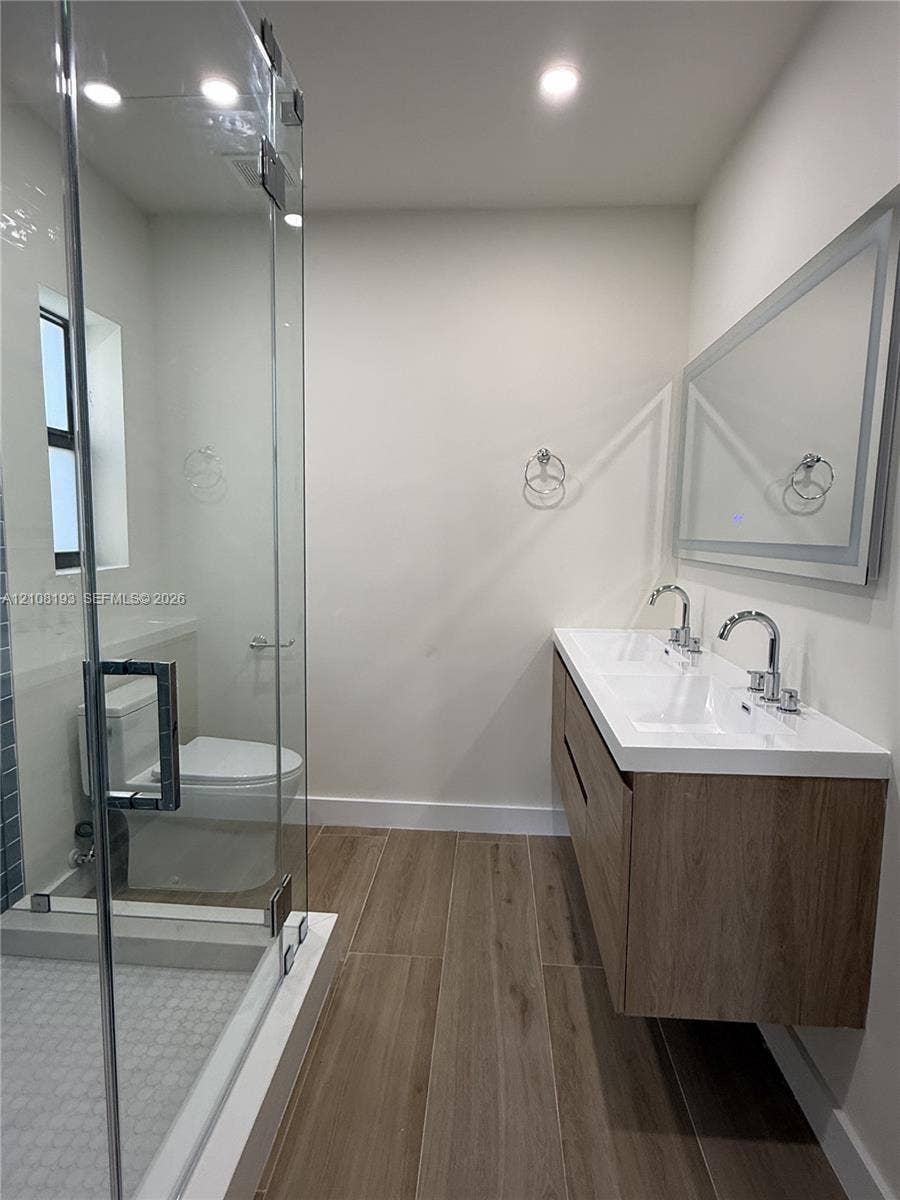 1929 SW 21st Street, #0, Miami, Miami, FL 33145 Floating vanity featuring a dual-sink integrated basin, wood-finish cabinetry, porcelain tile flooring, and a glass-enclosed shower with a modern chrome-finish hardware suite