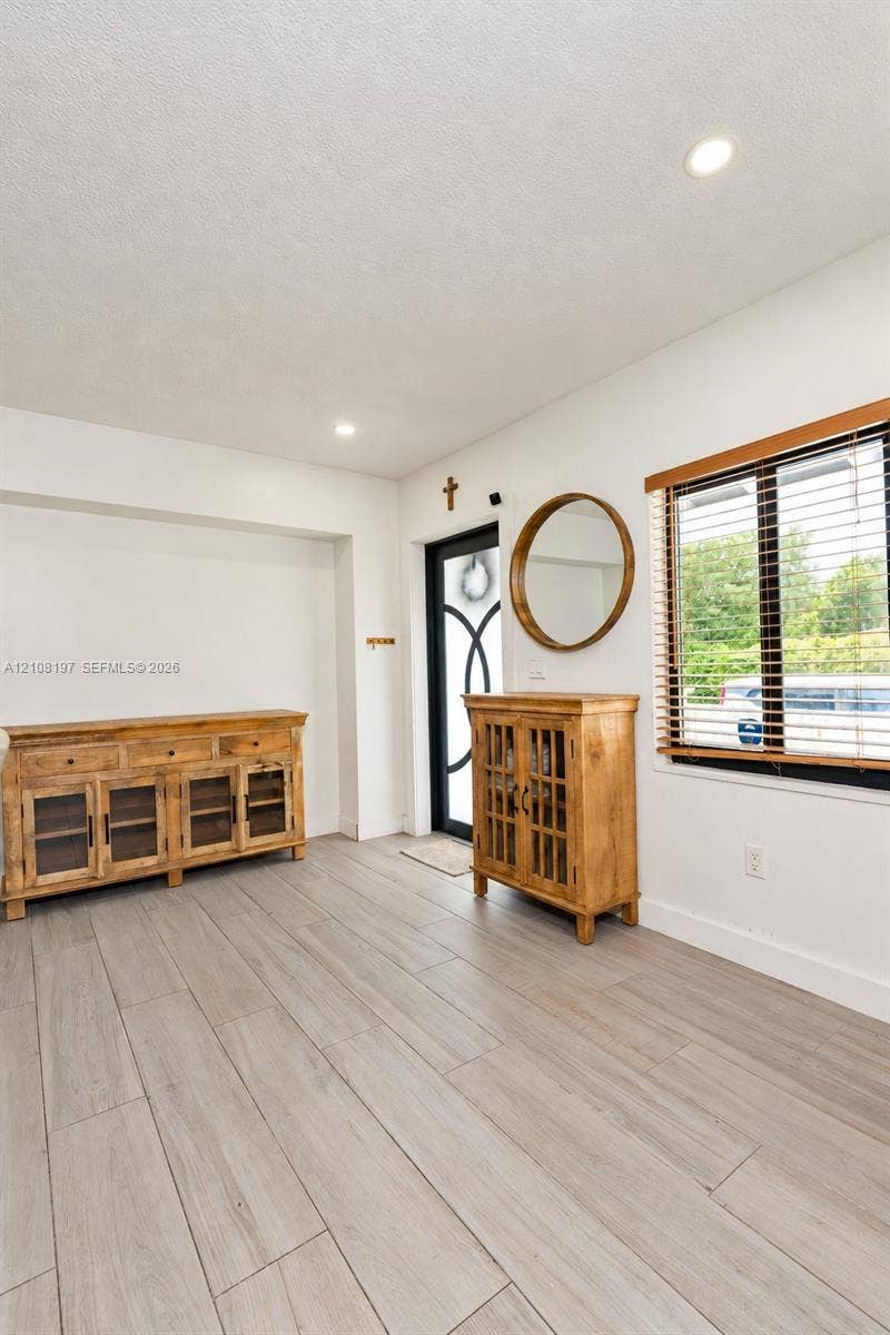 Wood-finish flooring, recessed lighting, and a front door with decorative glass paneling
