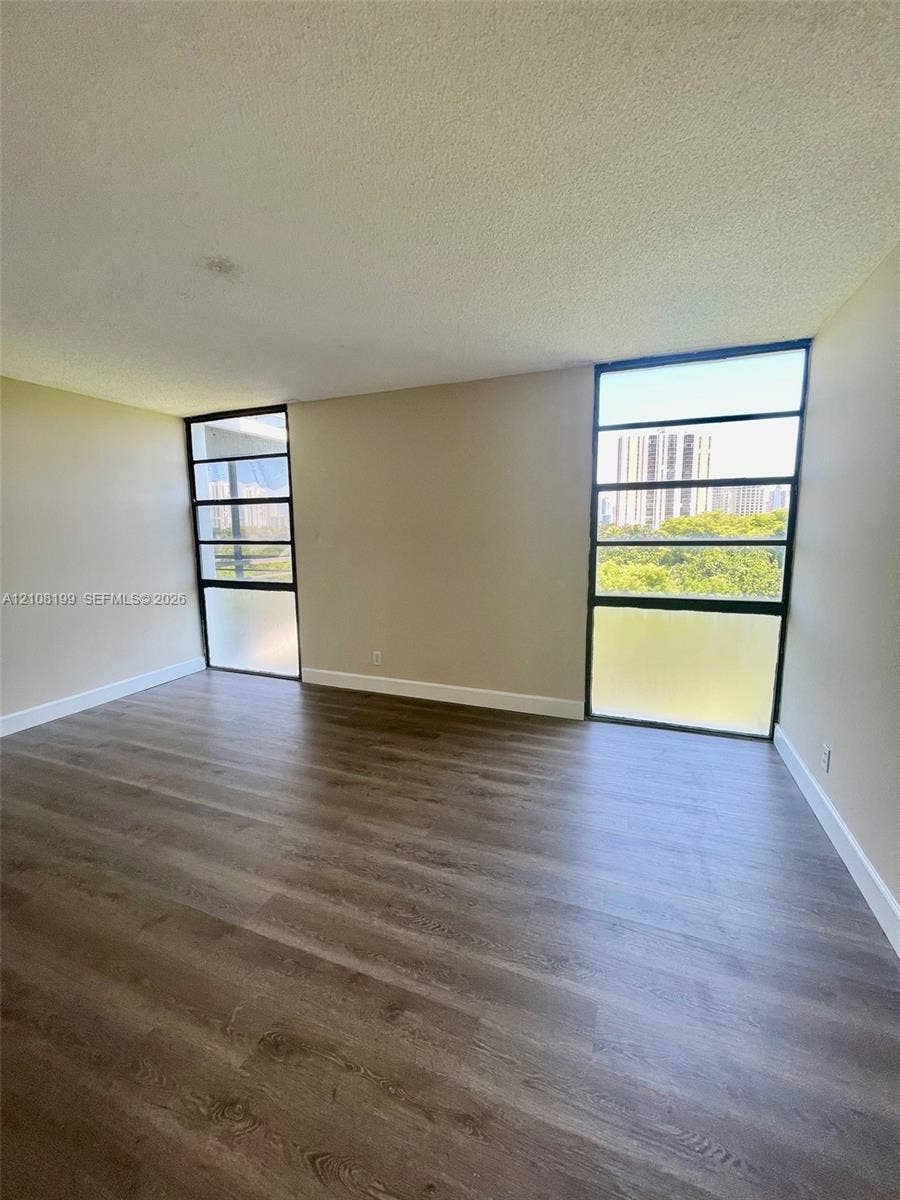20400 W Country Club Drive, #608, Aventura, Aventura, FL 33180 Living area featuring wood-finish flooring and floor-to-ceiling multi-pane windows with frosted glass lower panels