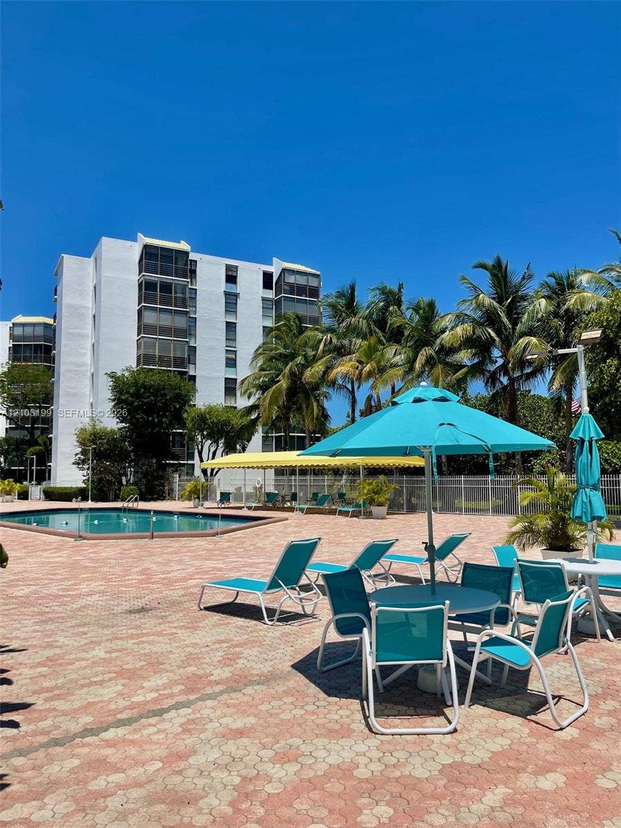 20400 W Country Club Drive, #608, Aventura, Aventura, FL 33180 Swimming pool with a paved deck, perimeter fencing, and mature palm trees