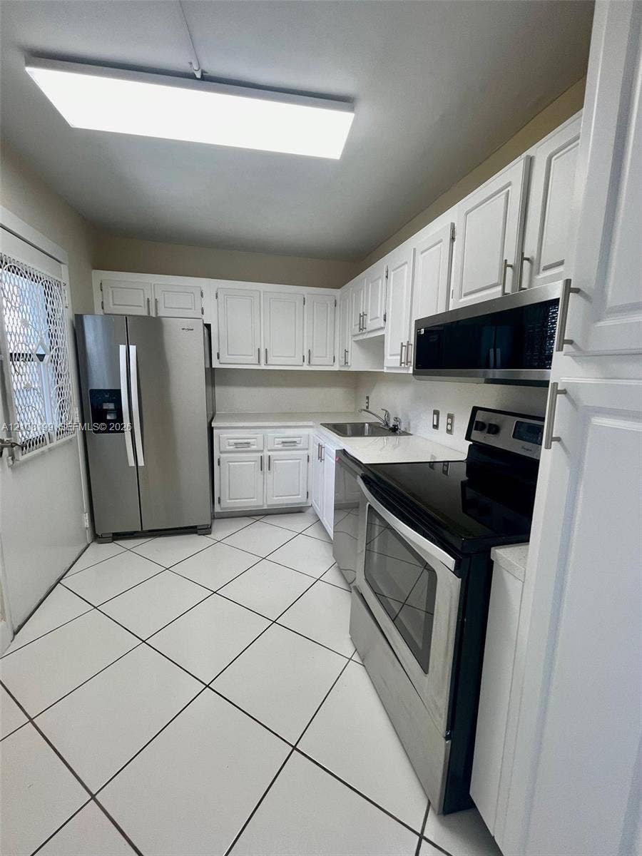 20400 W Country Club Drive, #608, Aventura, Aventura, FL 33180 Kitchen featuring white cabinetry, stainless steel appliances, solid-surface countertops, and diagonal-set tile flooring