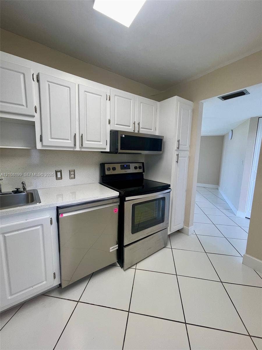 20400 W Country Club Drive, #608, Aventura, Aventura, FL 33180 Kitchen featuring white cabinetry, stone-finish countertops, stainless steel appliances, and tile flooring