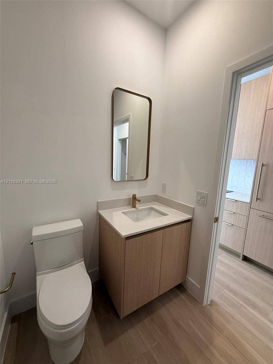 32 90 Ne 32 Street, #1115, Miami, Miami, FL 33127 Modern floating vanity with a neutral-tone countertop, rectangular undermount sink, brass-finish faucet, and coordinating wall-mounted mirror