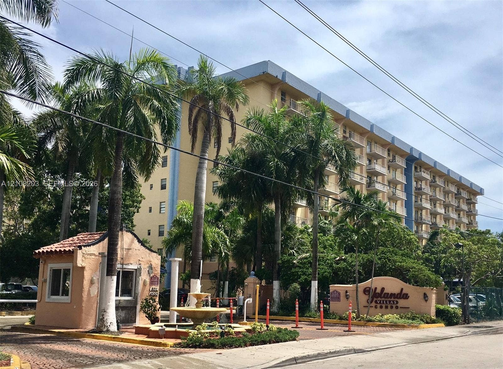 801 NW 47th Avenue, #619W, Miami, Miami, FL 33126 Multi-story residential complex featuring a gated entrance, a decorative tiered fountain, mature palm trees, and a paved brick driveway