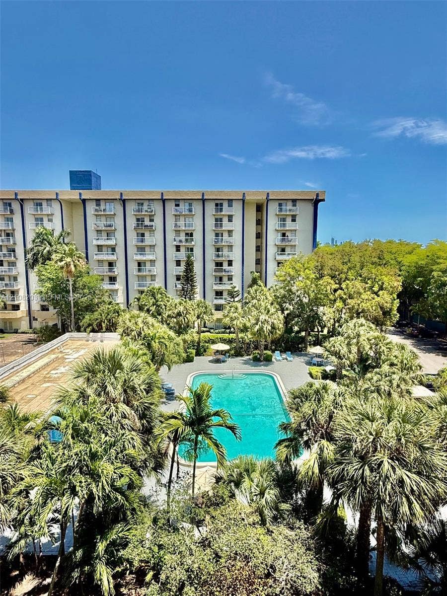 801 NW 47th Avenue, #619W, Miami, Miami, FL 33126 Multi-story residential building featuring private balconies, rectangular swimming pool, and extensive mature tropical landscaping