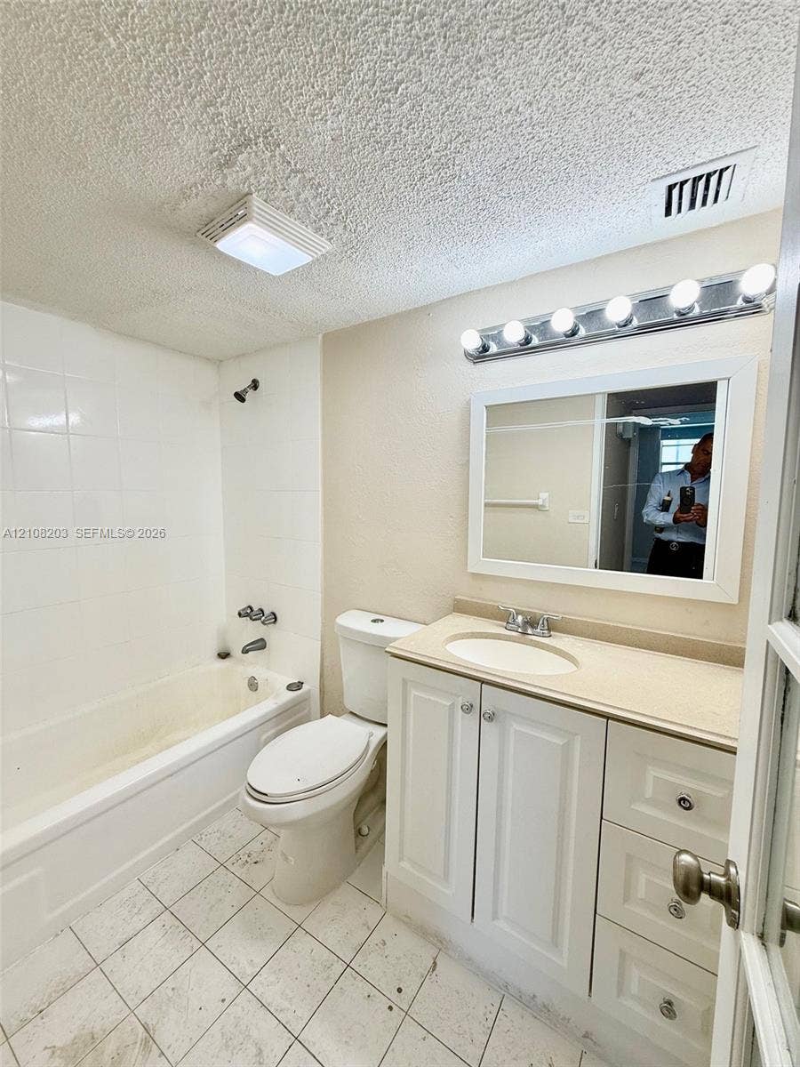801 NW 47th Avenue, #619W, Miami, Miami, FL 33126 Bathroom featuring a white vanity cabinet with an integrated sink, neutral countertop, rectangular mirror with a chrome five-light fixture, and a tiled shower-tub combination