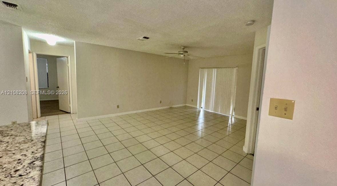 Coral Springs, Coral Springs, FL 33071 Open floor plan featuring tile flooring, ceiling fan, and sliding glass patio doors