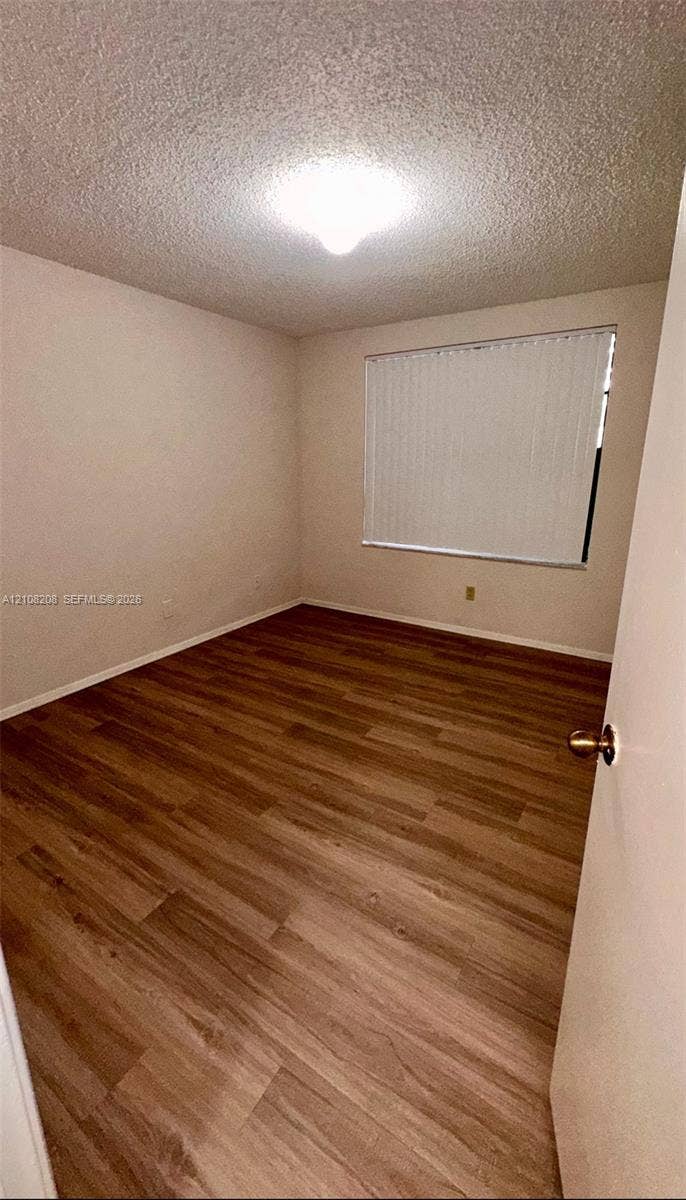 Coral Springs, Coral Springs, FL 33071 Room featuring wood-finish flooring, textured ceiling, flush-mount lighting, and window blinds