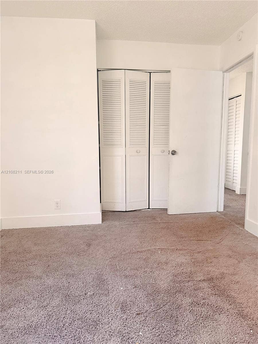5924 NW 21st Street, #49-A, Lauderhill, Lauderhill, FL 33313 Neutral-toned carpeting and white interior doors featuring louvered panels