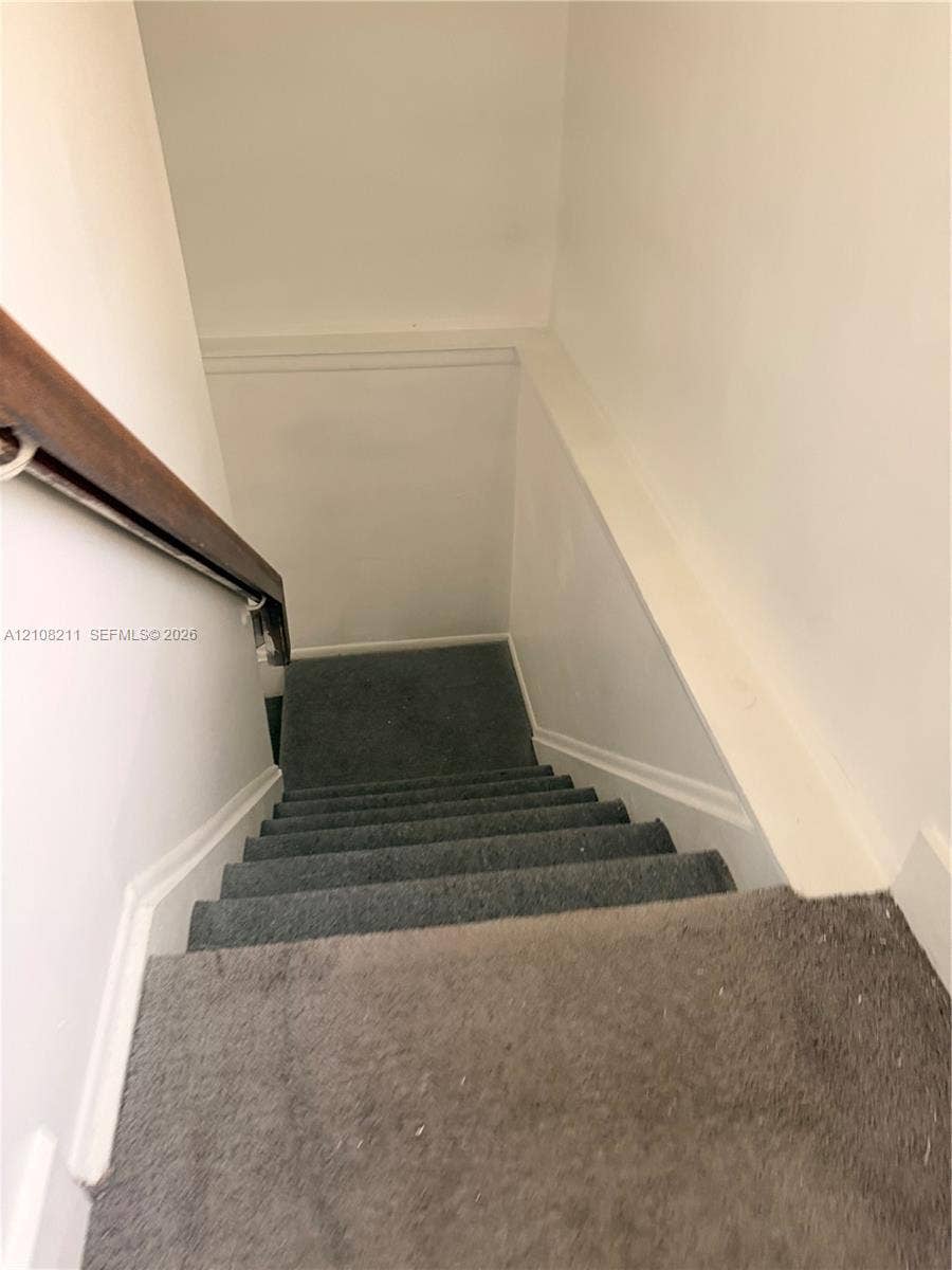 5924 NW 21st Street, #49-A, Lauderhill, Lauderhill, FL 33313 Carpeted staircase featuring a wooden handrail and white wall finishes