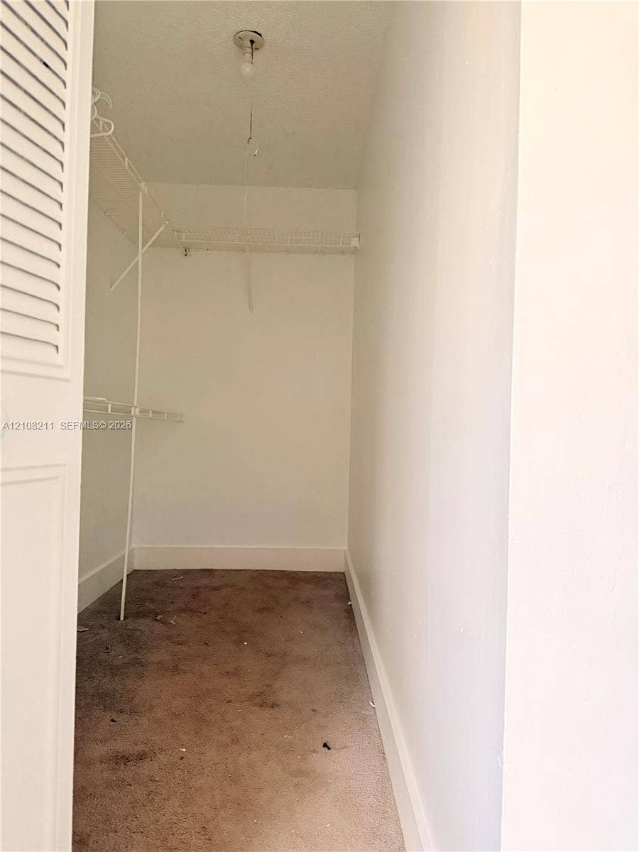 5924 NW 21st Street, #49-A, Lauderhill, Lauderhill, FL 33313 Storage closet featuring white-painted walls, carpeting, ceiling-mounted light fixture, and wire shelving system