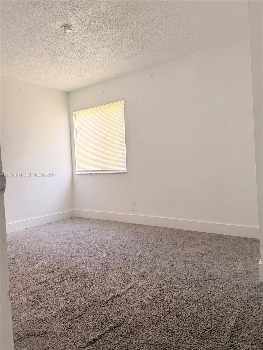 5924 NW 21st Street, #49-A, Lauderhill, Lauderhill, FL 33313 Room interior featuring neutral-toned carpeting, white walls, and a single window with installed blinds