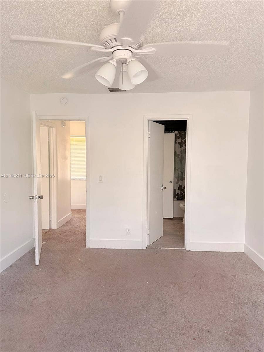 5924 NW 21st Street, #49-A, Lauderhill, Lauderhill, FL 33313 Neutral-toned wall-to-wall carpeting and a white multi-blade ceiling fan with integrated three-light fixture