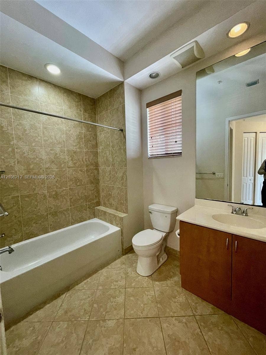 Sunrise, FL 33323 Bathroom featuring a tub-shower combination with tiled surround, large vanity with countertop sink, recessed ceiling lighting, and tile flooring