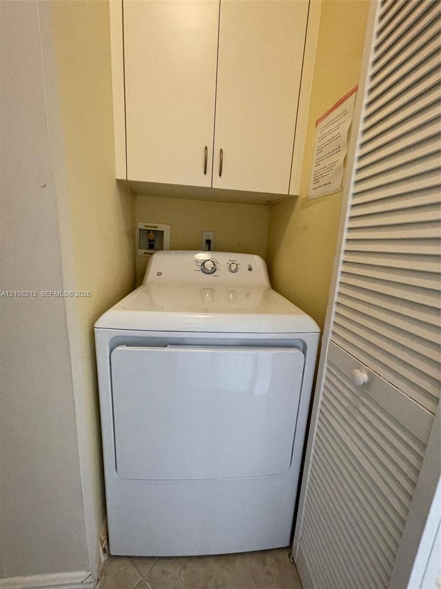 Sunrise, FL 33323 Built-in upper storage cabinetry, louvered closet door, and designated utility hookups