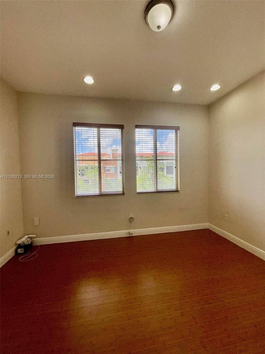 Sunrise, FL 33323 Interior room featuring wood-finish flooring, dual windows with blinds, recessed lighting, and a flush-mount ceiling fixture
