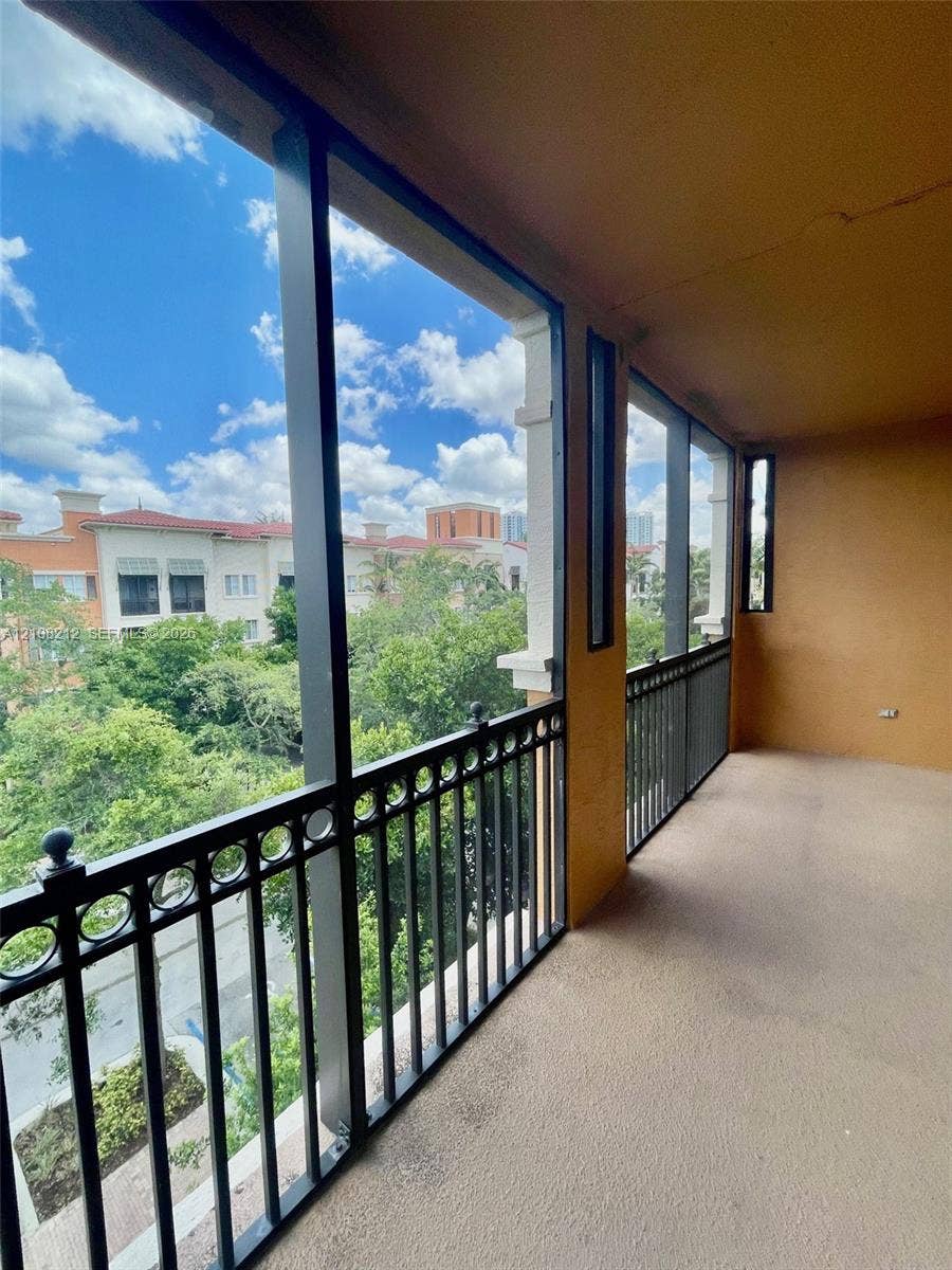 Sunrise, FL 33323 Covered balcony featuring screen enclosures, decorative metal railings, and concrete flooring