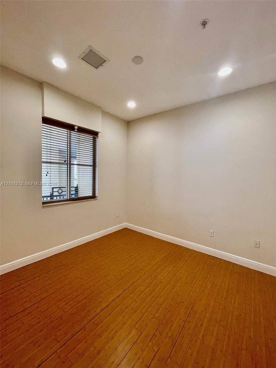 Sunrise, FL 33323 Room featuring wood-finish flooring, recessed lighting, and a window with horizontal blinds