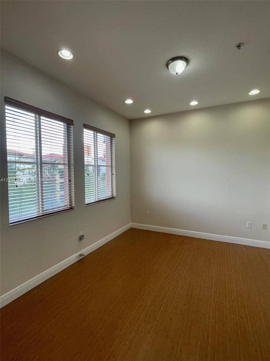 Sunrise, FL 33323 Room featuring wood-finish flooring, recessed lighting, neutral wall paint, and dual windows equipped with horizontal blinds