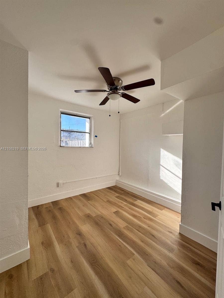 2381 NW 153rd Street, #2353, Miami Gardens, Miami Gardens, FL 33054 Interior space featuring wood-finish flooring, white walls, and a ceiling-mounted fan with integrated light fixture