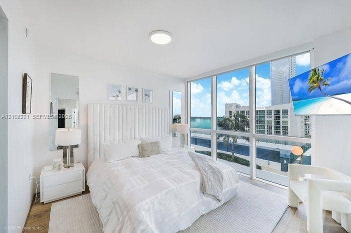 Floor-to-ceiling windows, wood-finish flooring, and recessed ceiling lighting