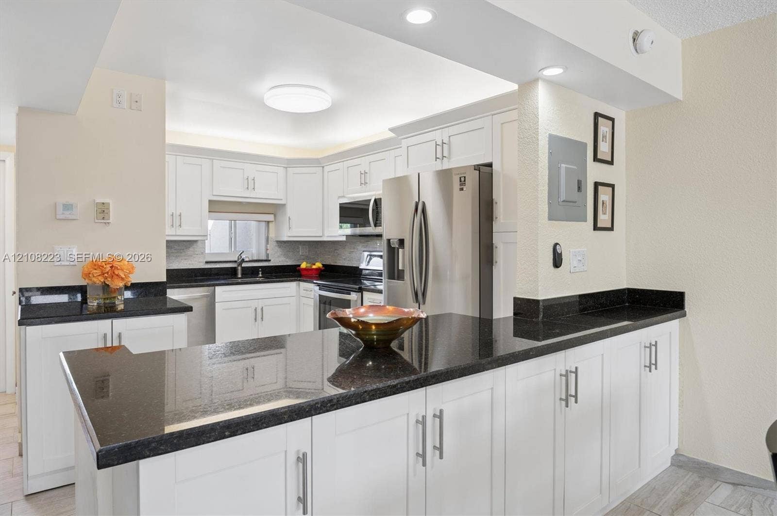 311 S Hollybrook Drive, #309, Pembroke Pines, FL 33025 Kitchen featuring white shaker-style cabinetry, dark stone countertops, stainless steel appliances, recessed ceiling lighting, and a breakfast bar