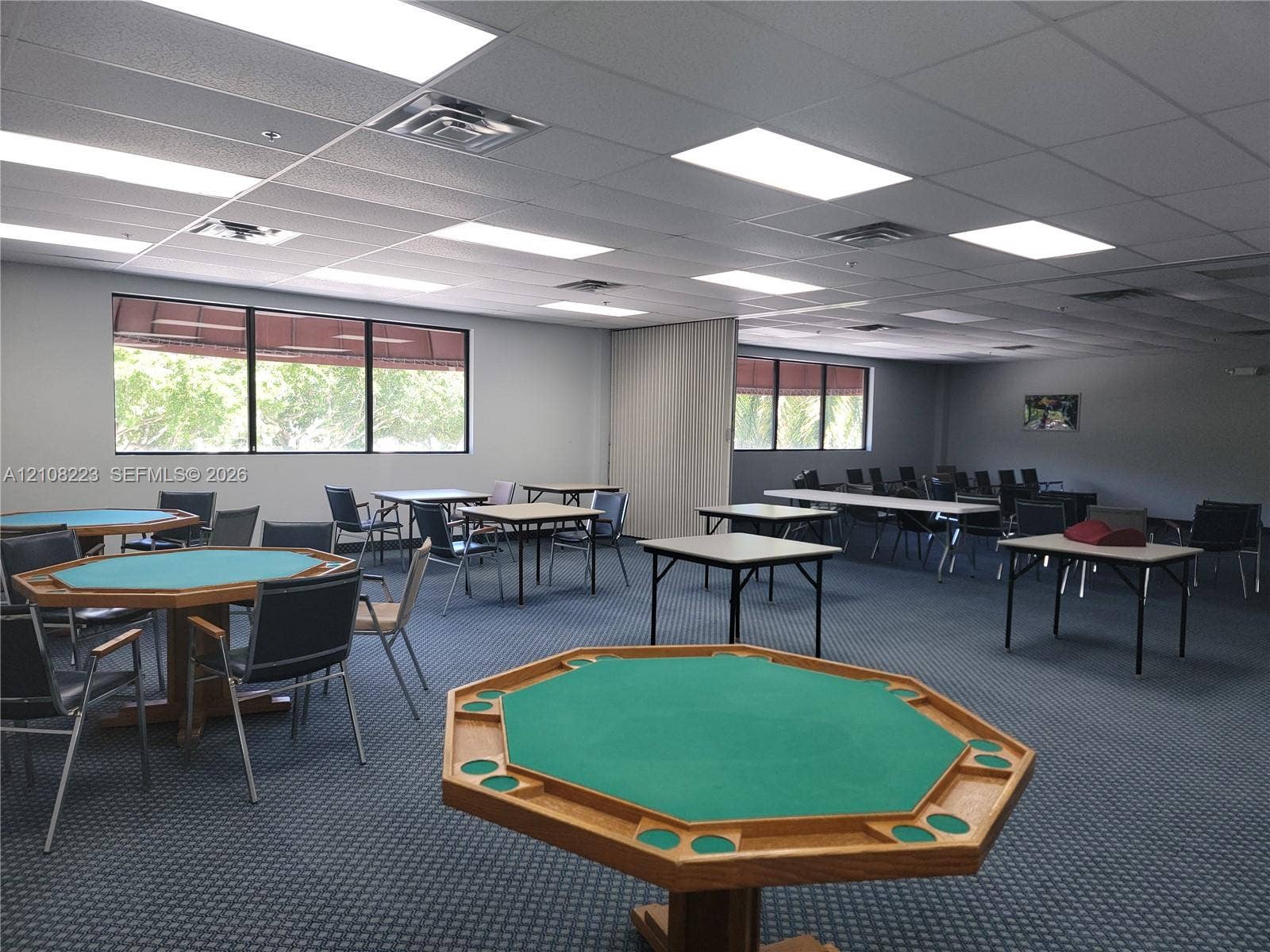 311 S Hollybrook Drive, #309, Pembroke Pines, FL 33025 Expansive multipurpose room featuring a drop ceiling with recessed lighting, integrated carpet flooring, and large windows