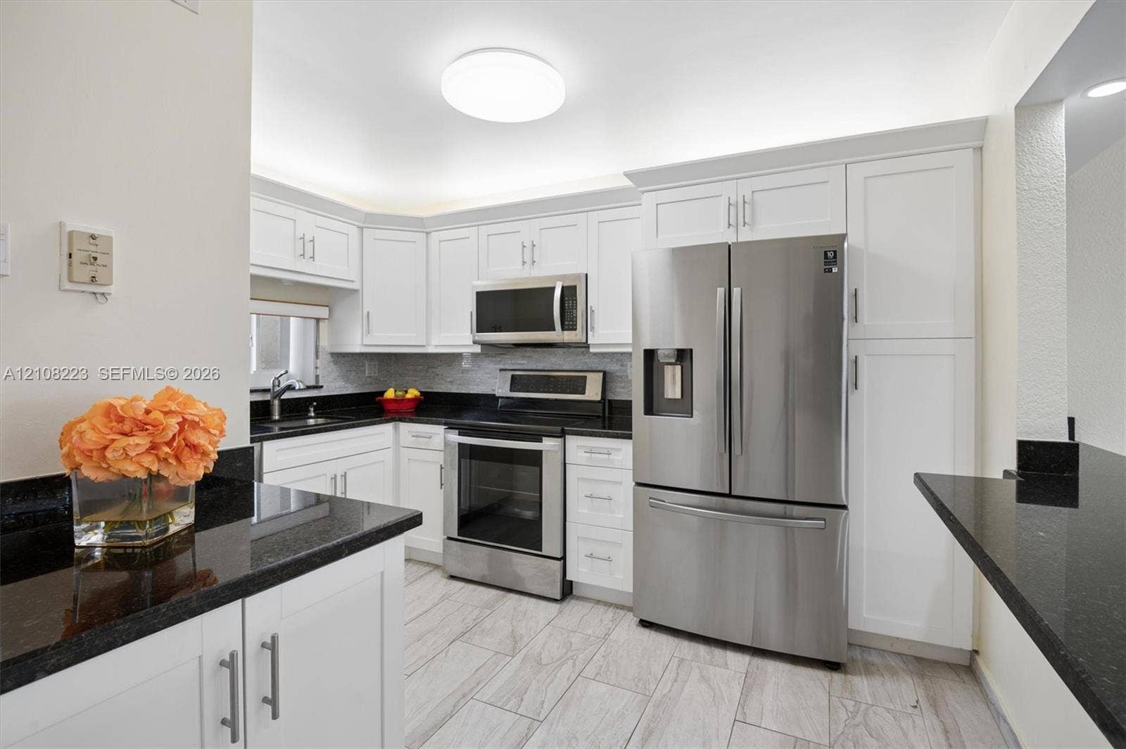 311 S Hollybrook Drive, #309, Pembroke Pines, FL 33025 Kitchen featuring white shaker-style cabinetry, black stone countertops, stainless steel appliances, and tile flooring