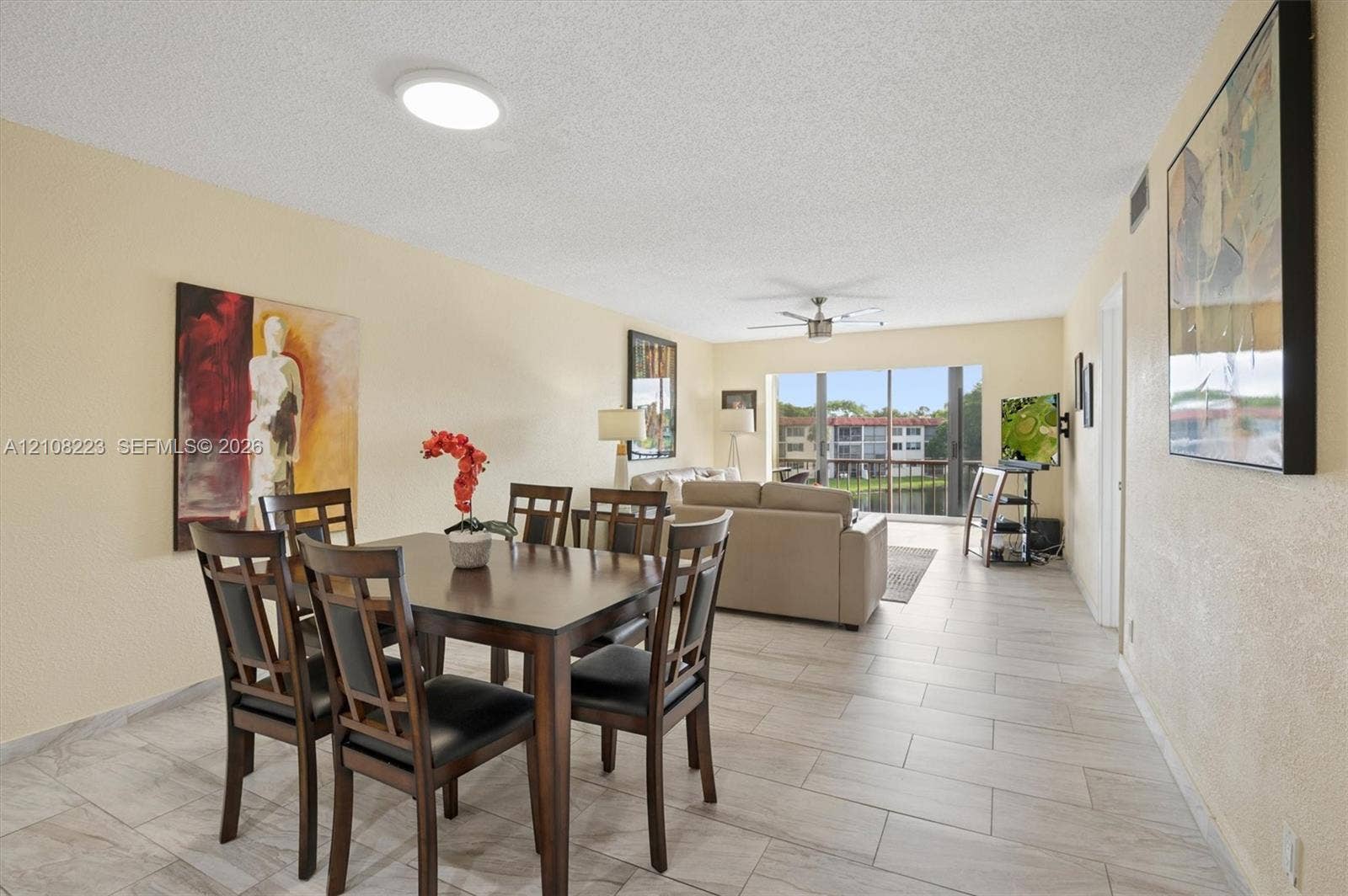 311 S Hollybrook Drive, #309, Pembroke Pines, FL 33025 Light-toned tile flooring, ceiling-mounted fan, and floor-to-ceiling sliding glass doors