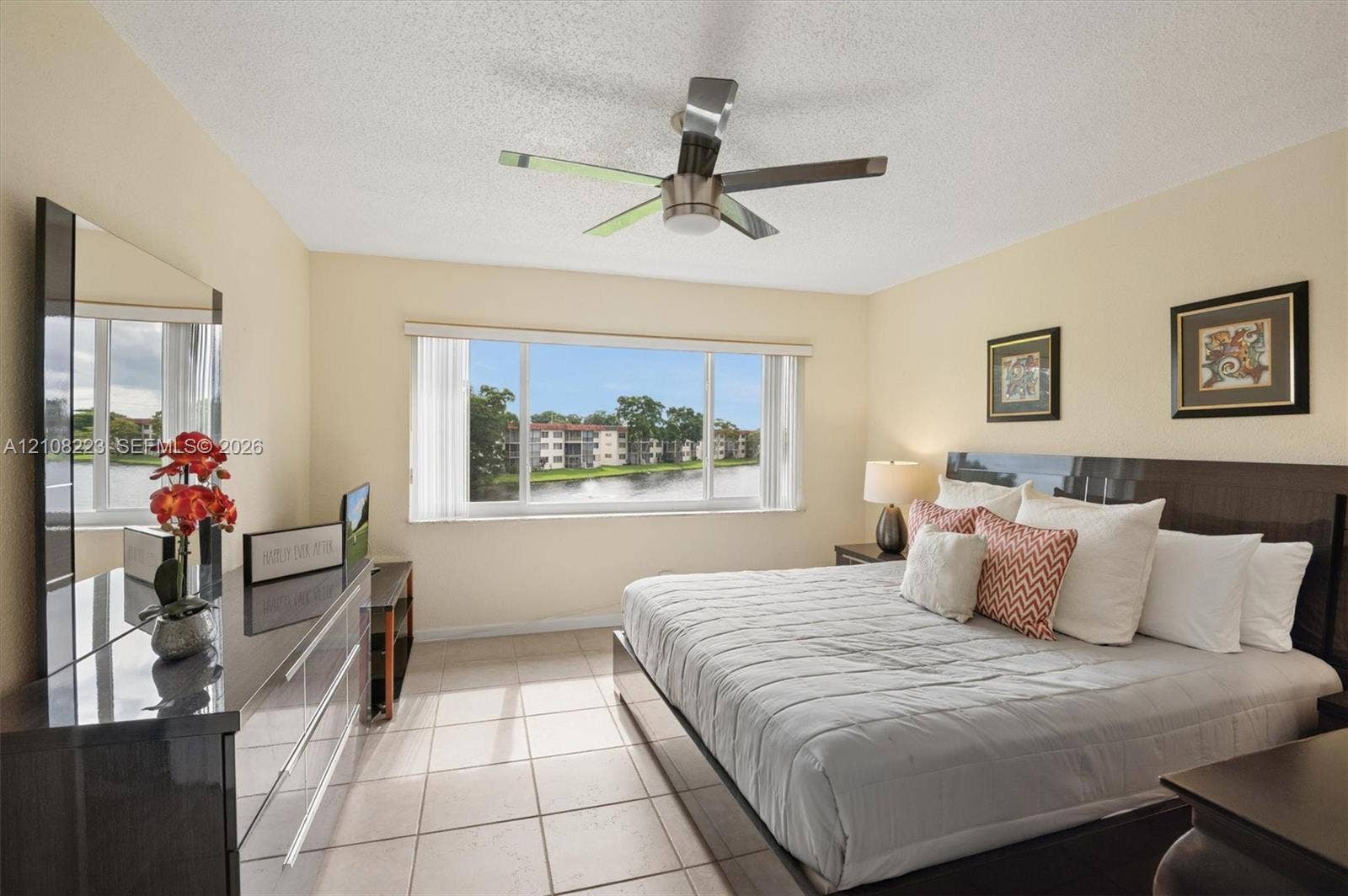 311 S Hollybrook Drive, #309, Pembroke Pines, FL 33025 Large horizontal window featuring water scenery, neutral tile flooring, and a modern ceiling fan