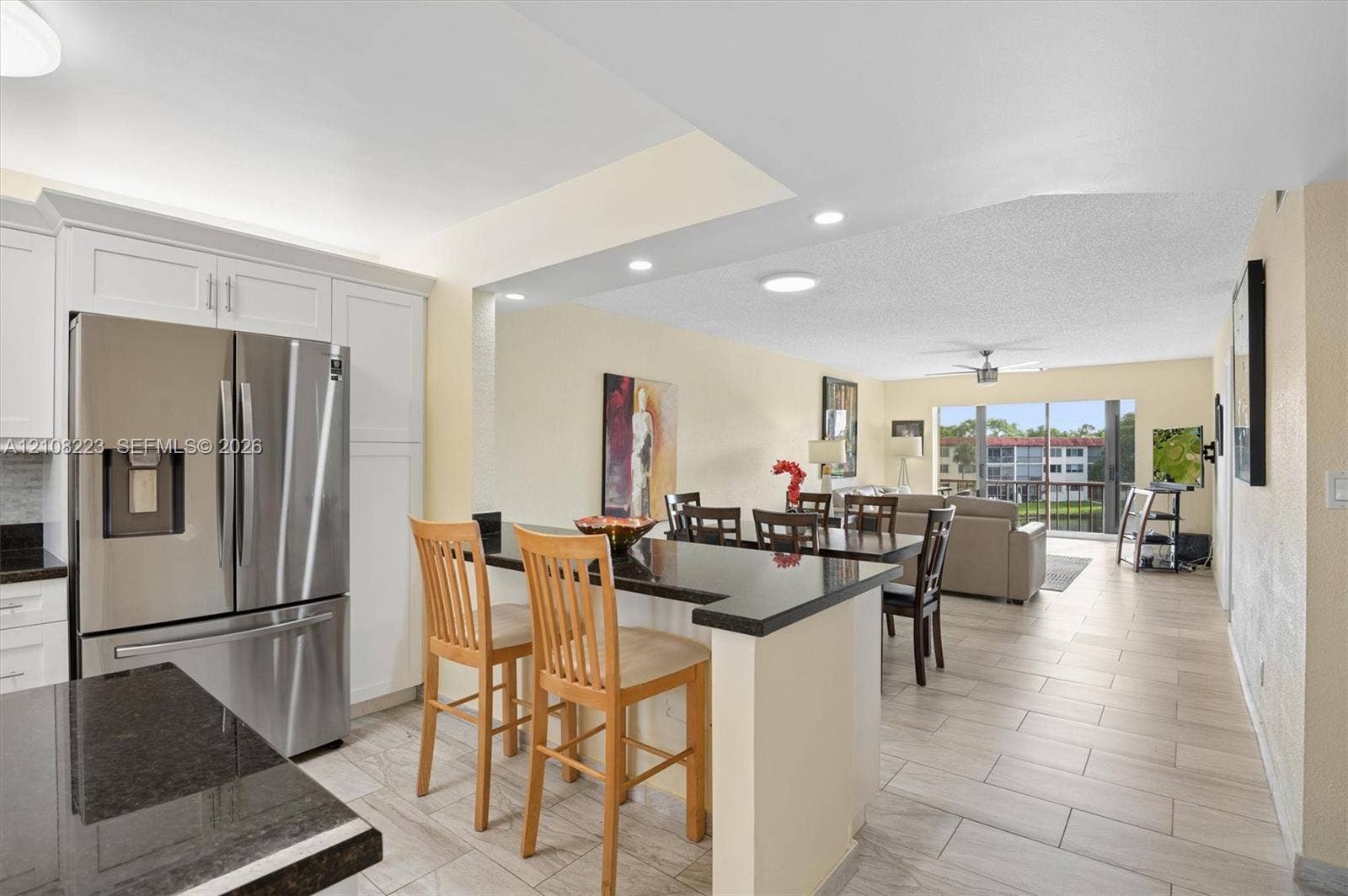 311 S Hollybrook Drive, #309, Pembroke Pines, FL 33025 Kitchen featuring white shaker-style cabinetry, dark stone countertops, stainless steel refrigerator, recessed lighting, and ceramic tile flooring