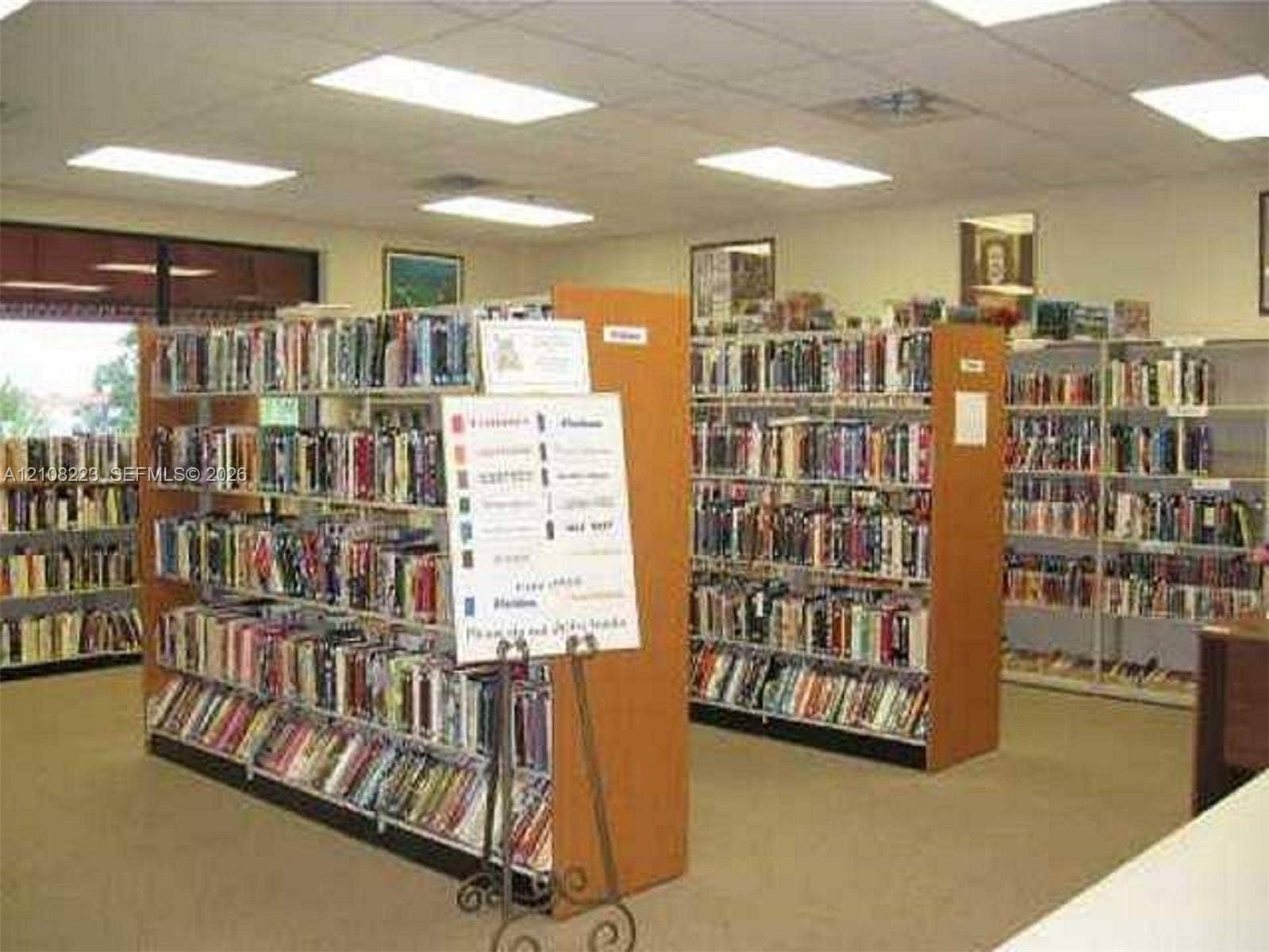 311 S Hollybrook Drive, #309, Pembroke Pines, FL 33025 Spacious room featuring neutral carpeting, recessed ceiling lighting, and multiple rows of built-in shelving units