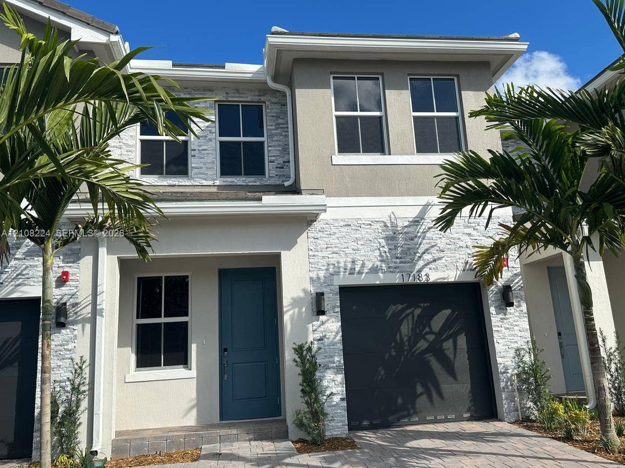 17183 SW 2nd Circle, #17183, Pembroke Pines, Pembroke Pines, FL 33027 Two-story exterior featuring a stone veneer facade, integrated single-car garage, multi-pane windows, and a covered entryway with a solid-panel door