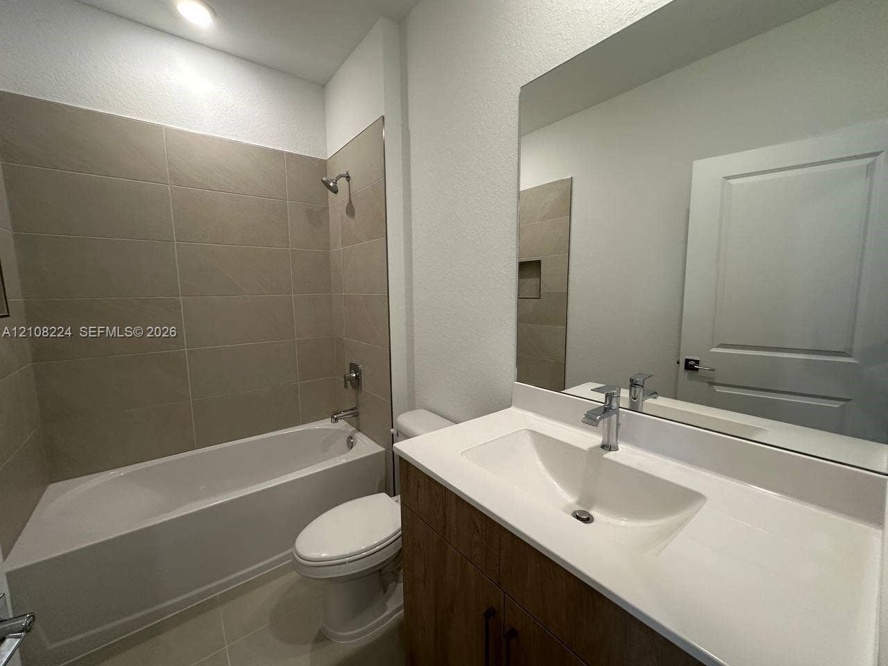 17183 SW 2nd Circle, #17183, Pembroke Pines, Pembroke Pines, FL 33027 Bathroom featuring a vanity with a white integrated sink, wood-finish cabinetry, a large wall-mounted mirror, and a tiled shower-tub combination