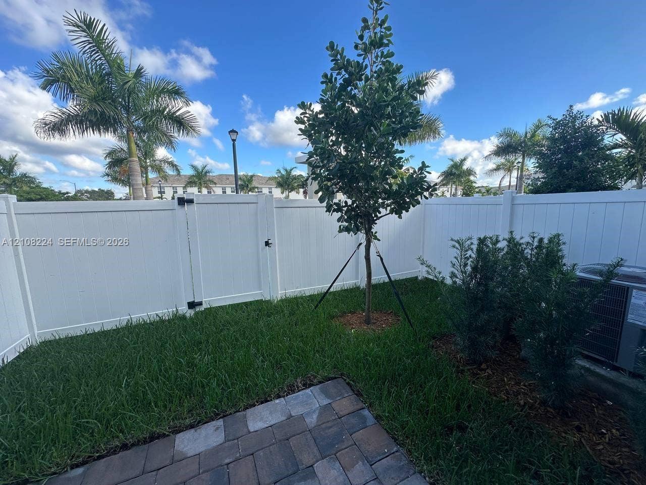17183 SW 2nd Circle, #17183, Pembroke Pines, Pembroke Pines, FL 33027 Fenced outdoor area featuring a paver patio, manicured lawn, established landscaping, and a gated entrance