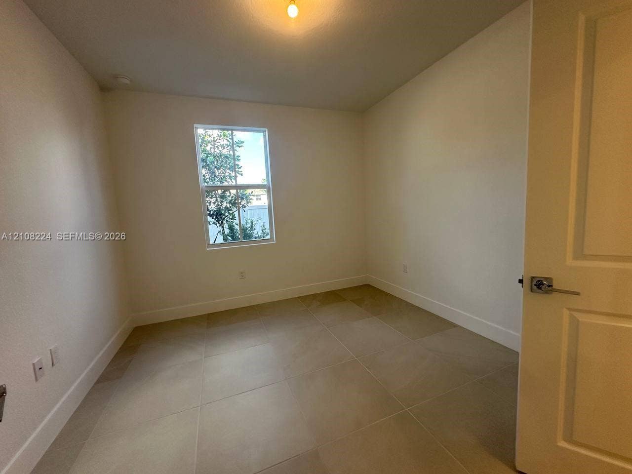 17183 SW 2nd Circle, #17183, Pembroke Pines, Pembroke Pines, FL 33027 Neutral-toned large-format tile flooring, single-hung window, white interior walls, and a multi-panel door with a satin-finish lever handle