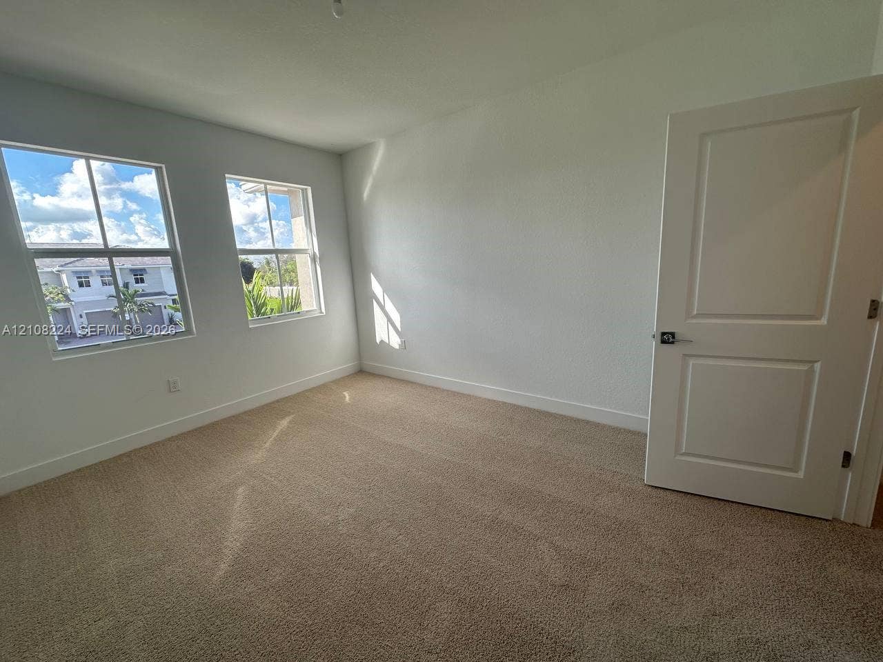 17183 SW 2nd Circle, #17183, Pembroke Pines, Pembroke Pines, FL 33027 Neutral-toned carpeting, two dual-pane windows, and a classic two-panel interior door