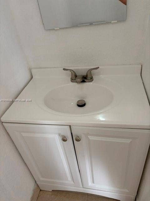 3200 Coral Springs Drive, Coral Springs, FL 33065 White vanity cabinet with recessed panel doors, integrated sink countertop, and dual-handle metal faucet