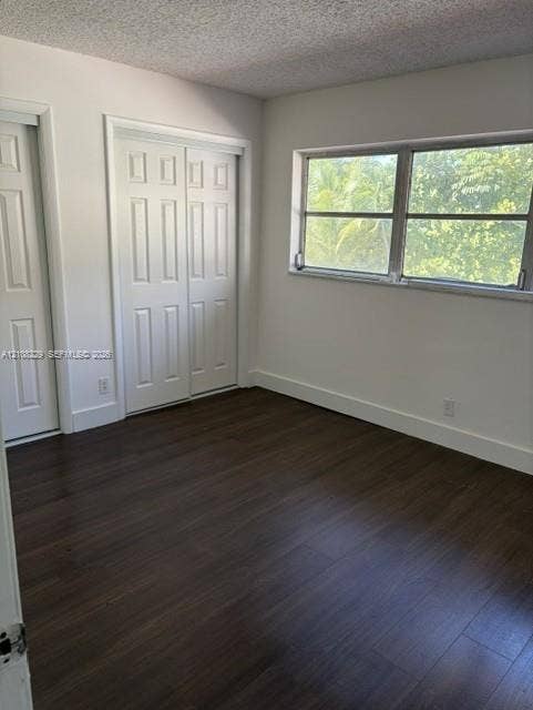 3200 Coral Springs Drive, Coral Springs, FL 33065 Room featuring wood-finish flooring, dual panel closet doors, and a single-pane horizontal window