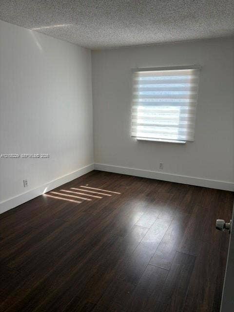 3200 Coral Springs Drive, Coral Springs, FL 33065 Interior room featuring wood-finish flooring, white walls, and a window with a dual-layer roller shade