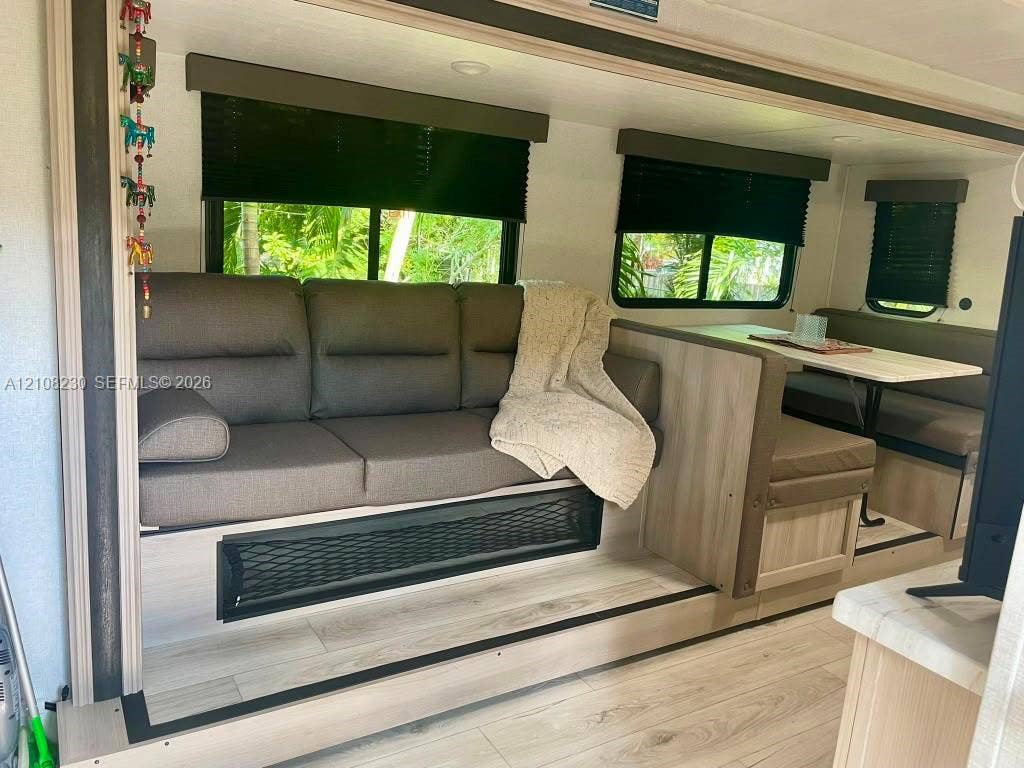 573 Mokena Drive, #1, Miami Springs, Miami Springs, FL 33166 Wood-finish flooring, light-toned built-in cabinetry, neutral-toned upholstery, and multiple windows with installed blinds