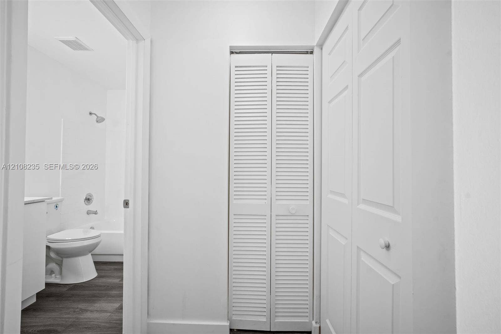 12752 SW 250th Terrace, Homestead, FL 33032 White bifold louvered closet doors, dual-panel interior doors, and wood-finish flooring
